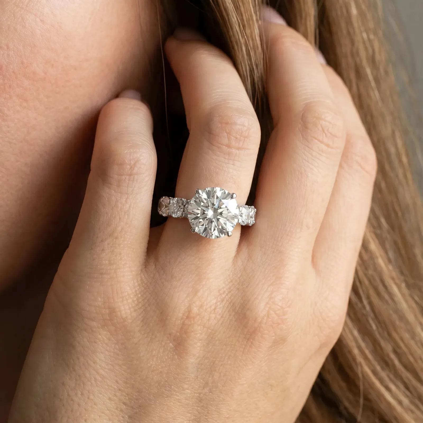 Round Cut Diamond Side Stone Engagement Ring with Four-Prong Setting White gold